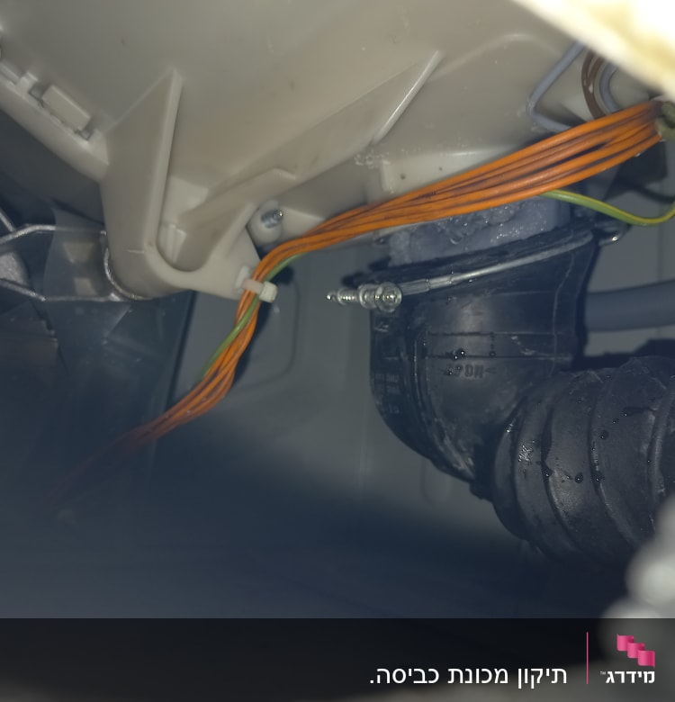 חוטי חשמל כתומים מחוברים לצינור פלסטיק שחור